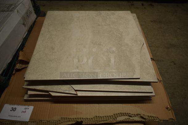 Stack of beige marble tiles with a few edges chipped, placed on cardboard. Tag indicates quantity of 30 tiles in lot.