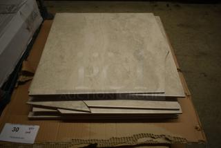 Stack of beige marble tiles with a few edges chipped, placed on cardboard. Tag indicates quantity of 30 tiles in lot.