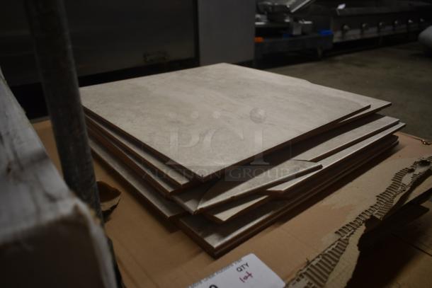 Stack of ceramic floor tiles, light gray, rectangular, new condition, stacked on cardboard. Label reads "14 qty lot."