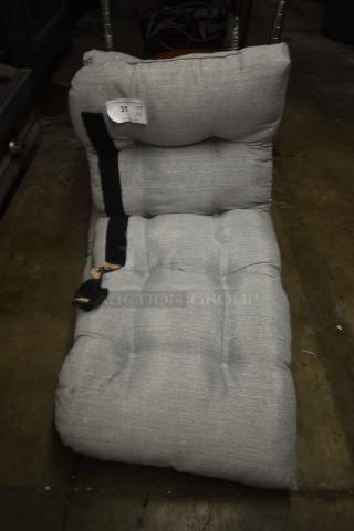 Gray tufted floor lounge chair with black strap, gently used. Tag reads "31 QTY X2". Shows slight wear on fabric.