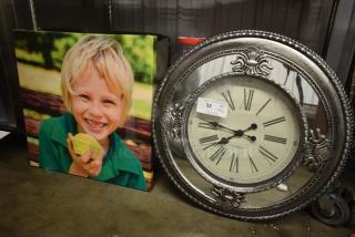 Vintage-style wall clock with ornate metal frame, Roman numerals, and visible tag indicating "32 qty." Canvas print of a child holding a cupcake.