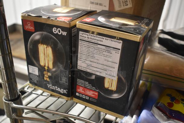 Two boxed Globe 60W vintage light bulbs on a shelf. Labels show brightness of 245 lumens and estimated energy cost of $7.23.