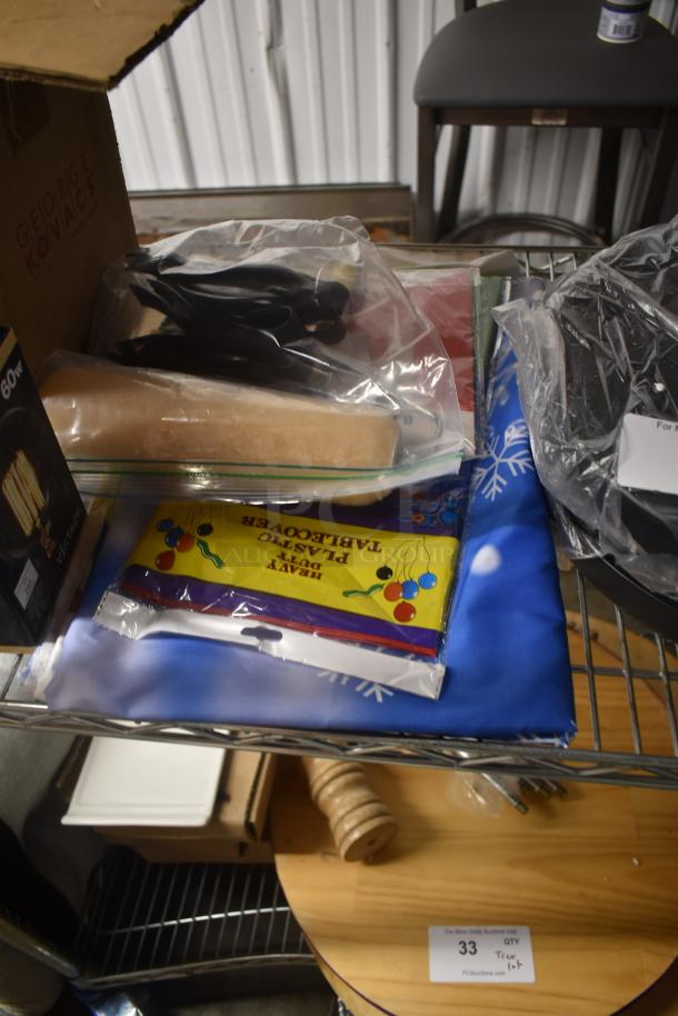 Assorted household items on a metal shelf, including a George Kovacs box, rolling pin, heavy-duty plastic table cover, and a light bulb box.