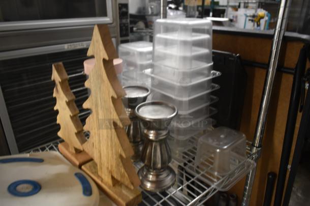 Wooden tree decor pieces, metal candle holders, and stacked plastic containers on a metal shelf. Items in good condition.
