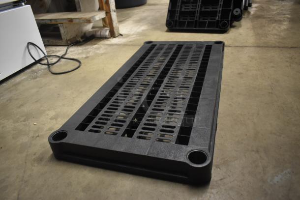 Black plastic shipping pallet with grid pattern, four rounded corners, and a flat, sturdy surface. Gently used condition.