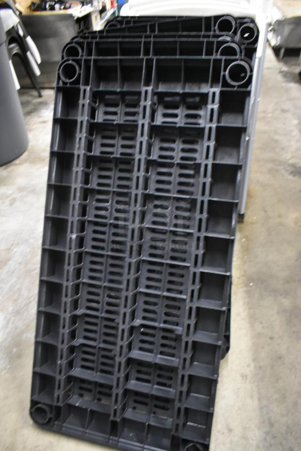 Black plastic stackable pallet, durable construction, ribbed design for strength, good condition, no visible markings.