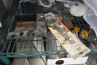 Metal shelf with black mounting bracket and new chrome peeler in packaging. Peeler package labeled "Lame Brittle" with fruit images.