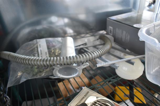 Industrial hose and fittings on metal shelf, new condition. Includes plastic container, instruction booklet visible.
