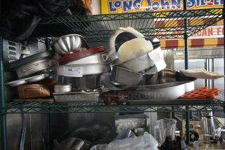 Assorted baking pans and molds on metal shelf, including Fat Daddio's brand, mixed materials, various shapes, lot tag 44.