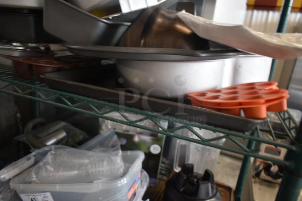 Assorted kitchenware including baking trays, pans, and a silicone mold on a metal shelf. Some plastic containers visible below.