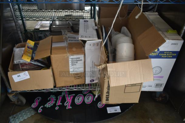 Various open boxes on a metal shelf containing assorted items like printer sheets and clear slotted flat lids. Labels indicate content details.
