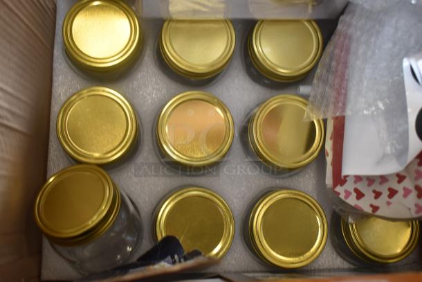Box of 12 glass jars with gold lids, neatly arranged in foam packaging, new condition.