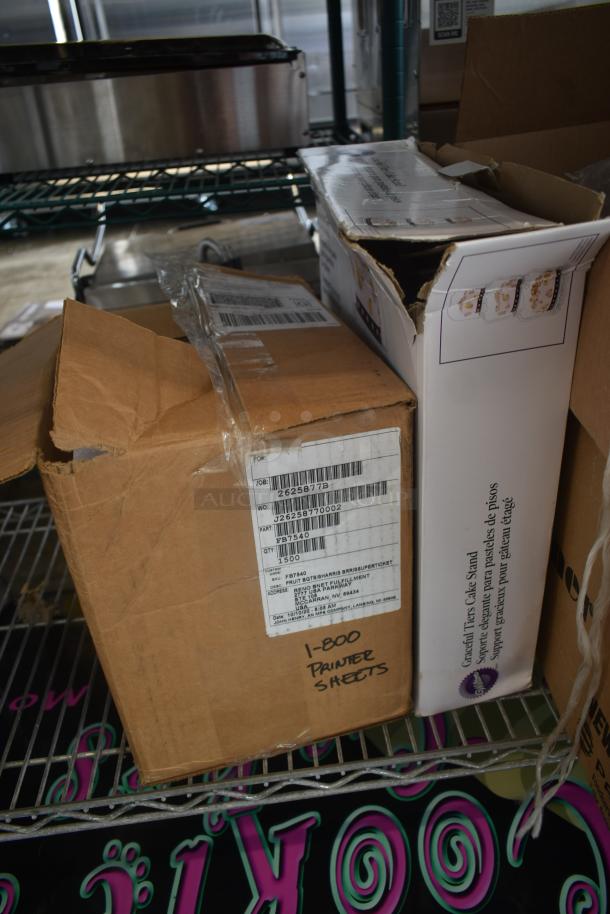 Cardboard box labeled "1-800 Printer Sheets" with a visible shipping label, showing signs of wear, on a metal shelf.