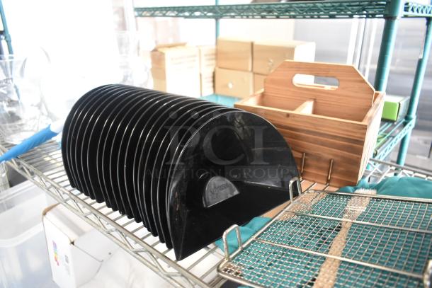 Black plastic dish rack, semi-circular design, in good condition, with an embossed label on a metal shelf unit.
