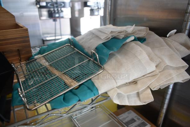 Metal cooling rack on teal and beige cloths, in good condition, resting on a wire shelf.