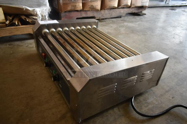 Commercial hot dog roller grill with nine rollers, stainless steel finish, used condition, temperature controls, visible wear.