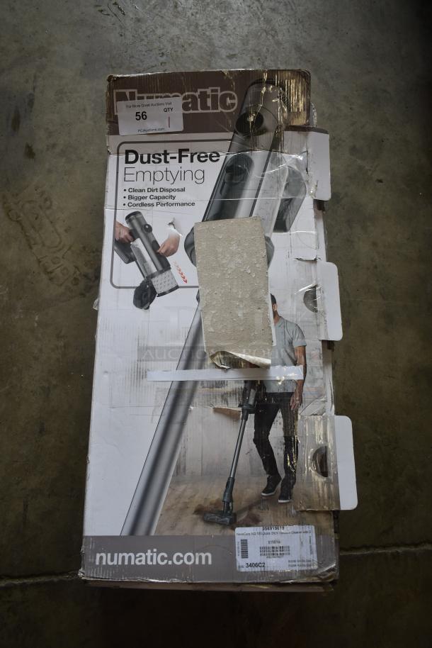 Numatic vacuum cleaner box, slightly damaged. Features include dust-free emptying, cordless operation. Labels indicate model 915916.