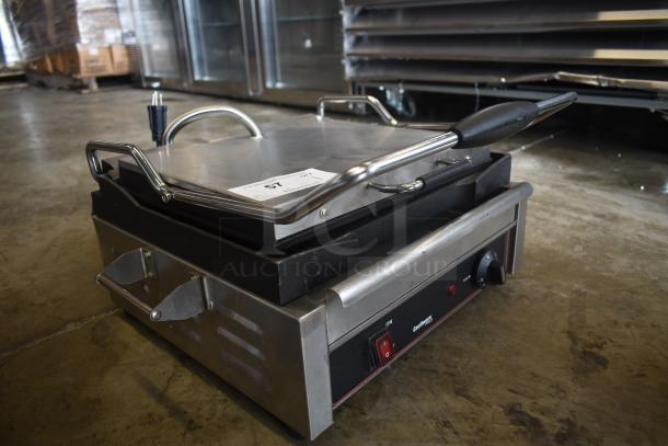 Commercial panini press with stainless steel handles, black base, and temperature control knob. Tag reads "57."