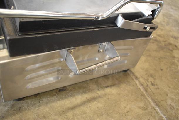 Stainless steel sandwich press with polished handle and black top, in good condition.