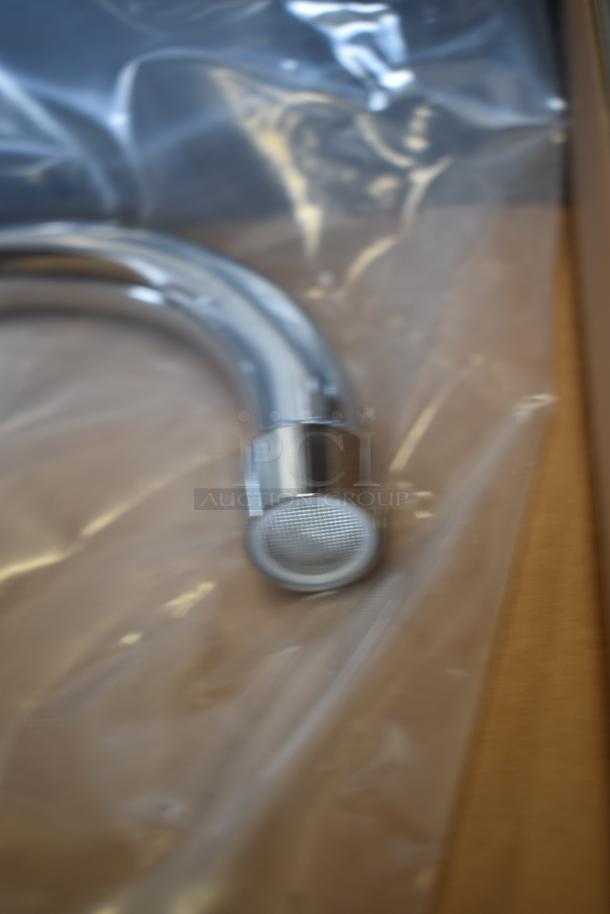 Chrome kitchen faucet spout in new condition, wrapped in clear plastic packaging, with a round mesh aerator visible.