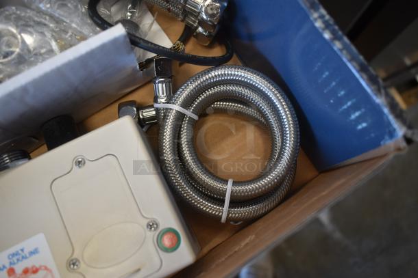Metal braided hose with fittings and a control box in a cardboard box, new condition. Safety label reads "Only for alkaline."