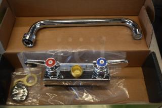 Chrome kitchen faucet set in box, featuring a swivel spout and dual-handle controls for hot and cold water, unused condition.