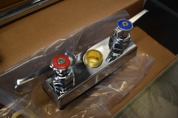 Chrome bathroom faucet with dual handles, color-coded red and blue for hot and cold, in new condition, in packaging.