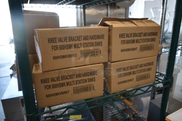 Cardboard boxes labeled "Knee Valve Bracket and Hardware for 600HSMK Multi Station Sinks," stored on a metal shelf.