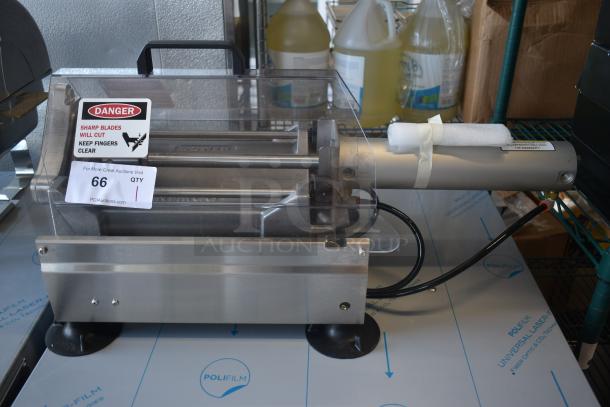 Commercial deli meat slicer with clear safety cover, metal construction, and warning label. Item number 66 on auction.