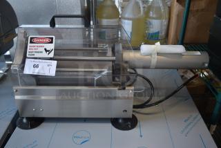 Commercial deli meat slicer with clear safety cover, metal construction, and warning label. Item number 66 on auction.