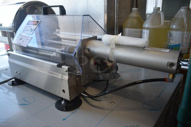 Commercial deli meat slicer with safety casing, metal body, and visible caution label. In good used condition.