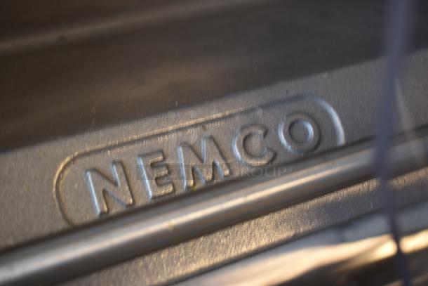 Close-up of a metal surface with the embossed brand name "NEMCO." High-quality finish, no visible damage.