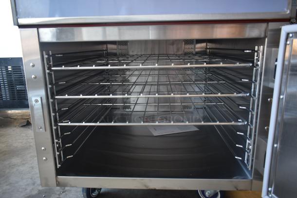 Commercial stainless steel oven with multiple wire racks, clean interior, and wheels for mobility. Instructions visible inside.