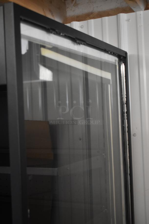 Glass-front metal display cabinet, black frame, visible shelving; shows light wear on edges, in good used condition.