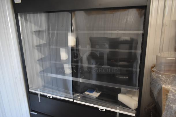 Black refrigerated display case with multiple shelves, in new condition, partially wrapped in protective plastic, set against a corrugated wall.