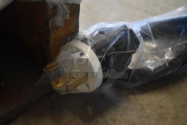 Heavy-duty electrical plug in plastic wrap, gold prongs visible, indicating new condition.