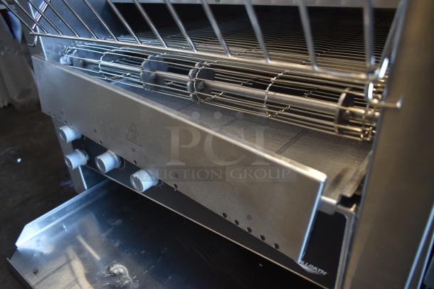 Commercial countertop toaster oven with adjustable knobs, wire rack, and stainless steel finish. Brand markings partially visible.