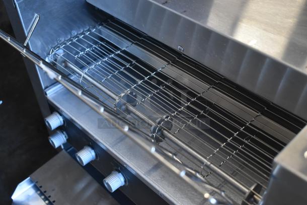 Commercial stainless steel rotisserie oven with multiple adjustable racks and control knobs, in excellent condition.