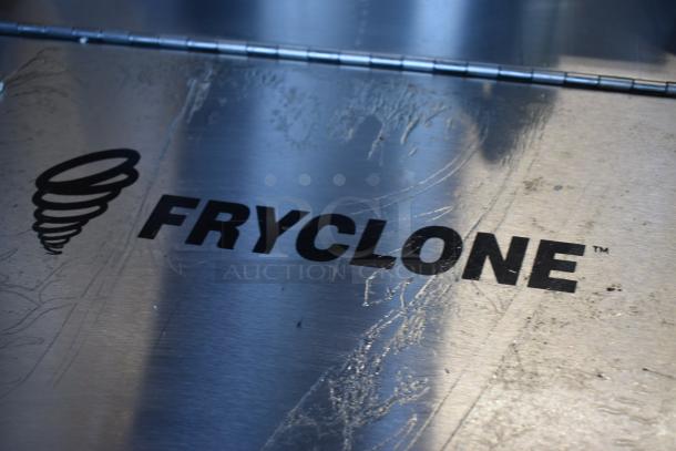 Stainless steel Fryclone cover with logo and swirl graphic; surface shows visible scratches, indicating use.
