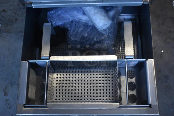 Stainless steel fry station basket with perforated base, includes bubble-wrapped items inside. Appears in excellent condition.
