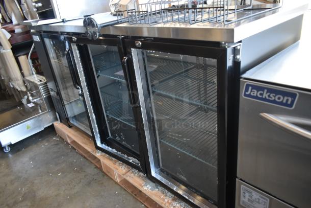 Commercial glass-door refrigerator with black frame, two sections, shelves inside, slight wear. "Jackson" label visible.