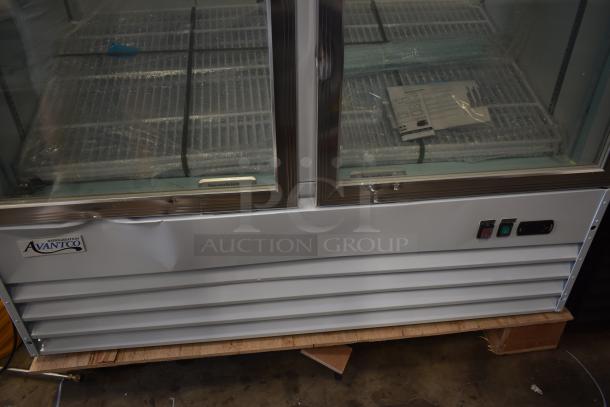 Avantco commercial refrigerator, two-door glass front, silver finish, visible dent on panel, with control switches.