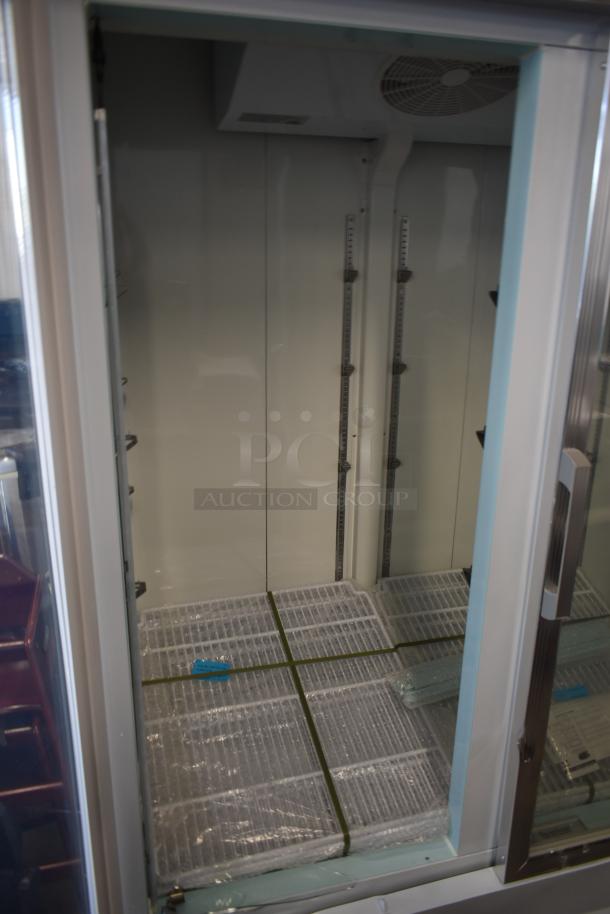 Commercial glass-door refrigerator, empty interior, adjustable shelves, visible packaging, excellent condition, ready for use.
