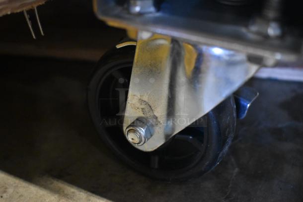 Heavy-duty caster wheel with metal bracket, some wear visible, suitable for industrial furniture or carts.