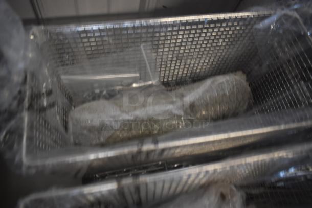 Blurred metal basket with plastic-wrapped object inside, unclear details and features.