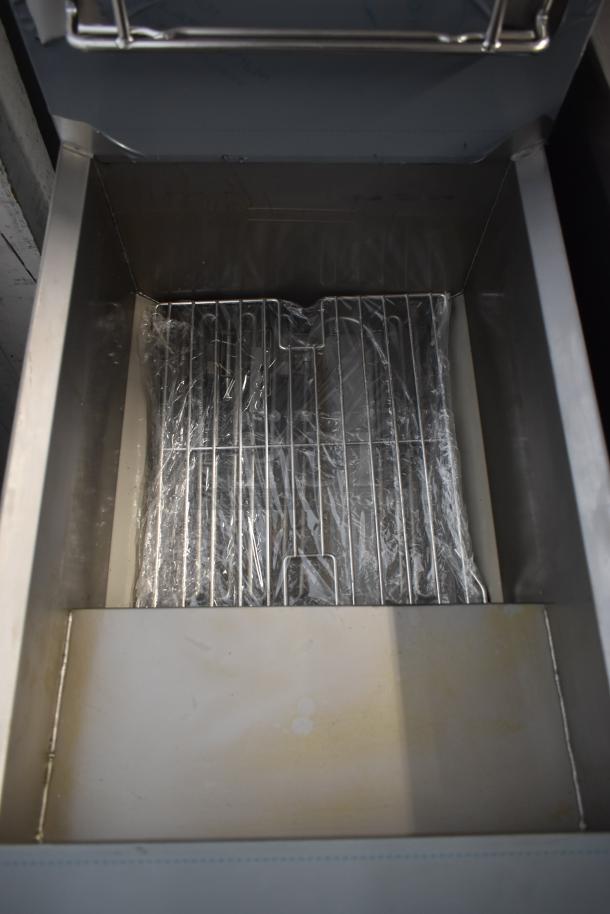 Stainless steel deep fryer drawer with wire rack, new and sealed in plastic, offering durability and easy maintenance.