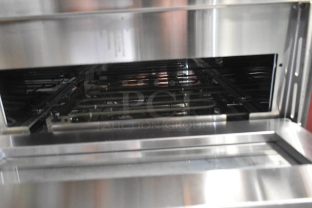 Commercial stainless steel oven interior with visible heating coils, clean condition, reflective surfaces.