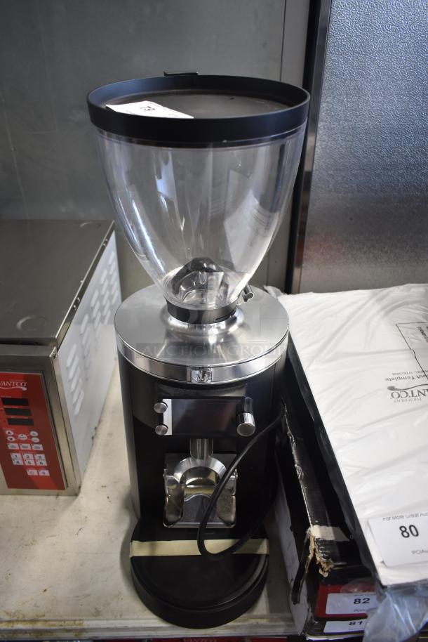 Commercial coffee grinder with clear bean hopper, black and silver finish, model number on sticker. Appears in good condition.
