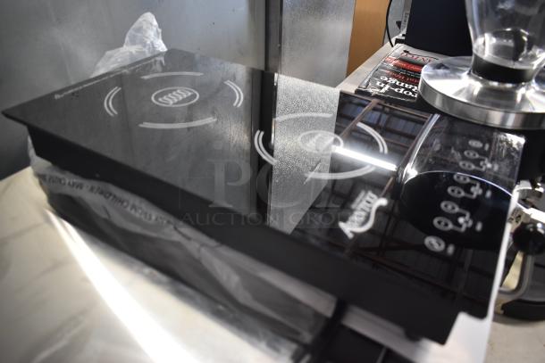 Induction cooktop with dual heating zones, sleek black glass surface, touch controls, and visible brand marking. Mint condition.