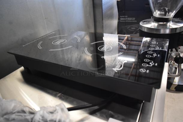 Black glass induction cooktop with four hobs. Features control panel, power levels marked. In excellent condition.